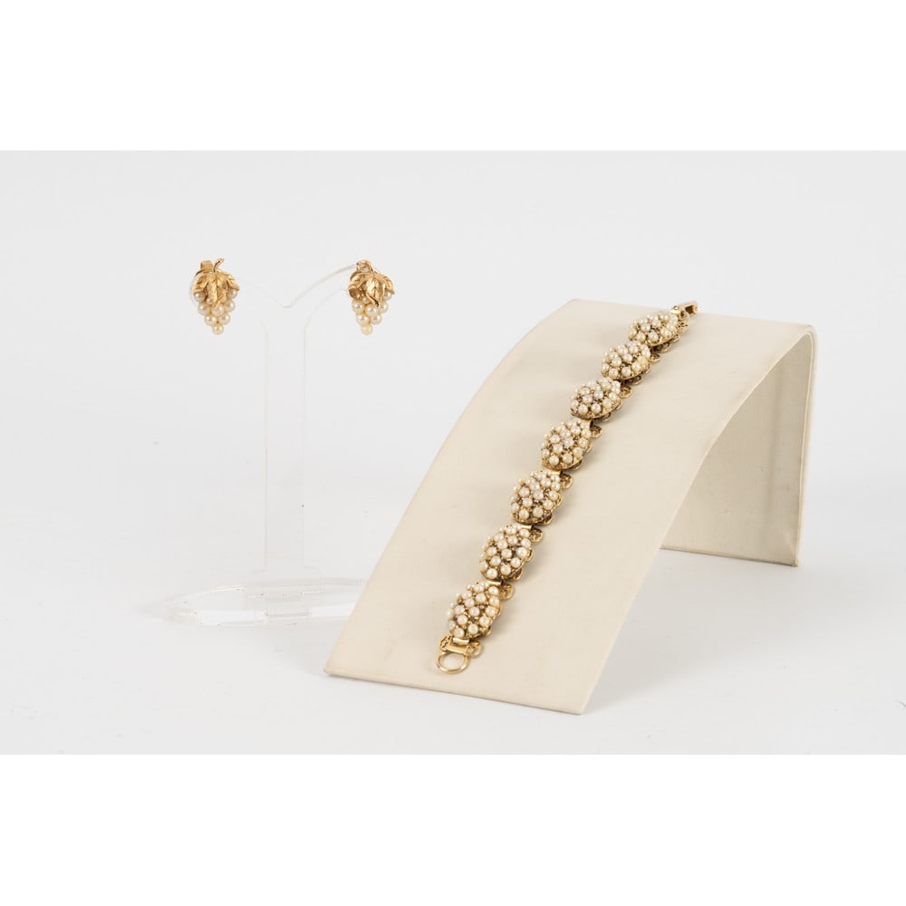 TRIFARI, Parure composta da due pezzi: TRIFARI Produzione U.S.A. 1960 ca.Parure composta da due pezzi; un bracciale semi rigido con montatura in metallo dorato, ovali con perle, chiusura a fermaglio . Marchio di produzione. Orecchini con m
