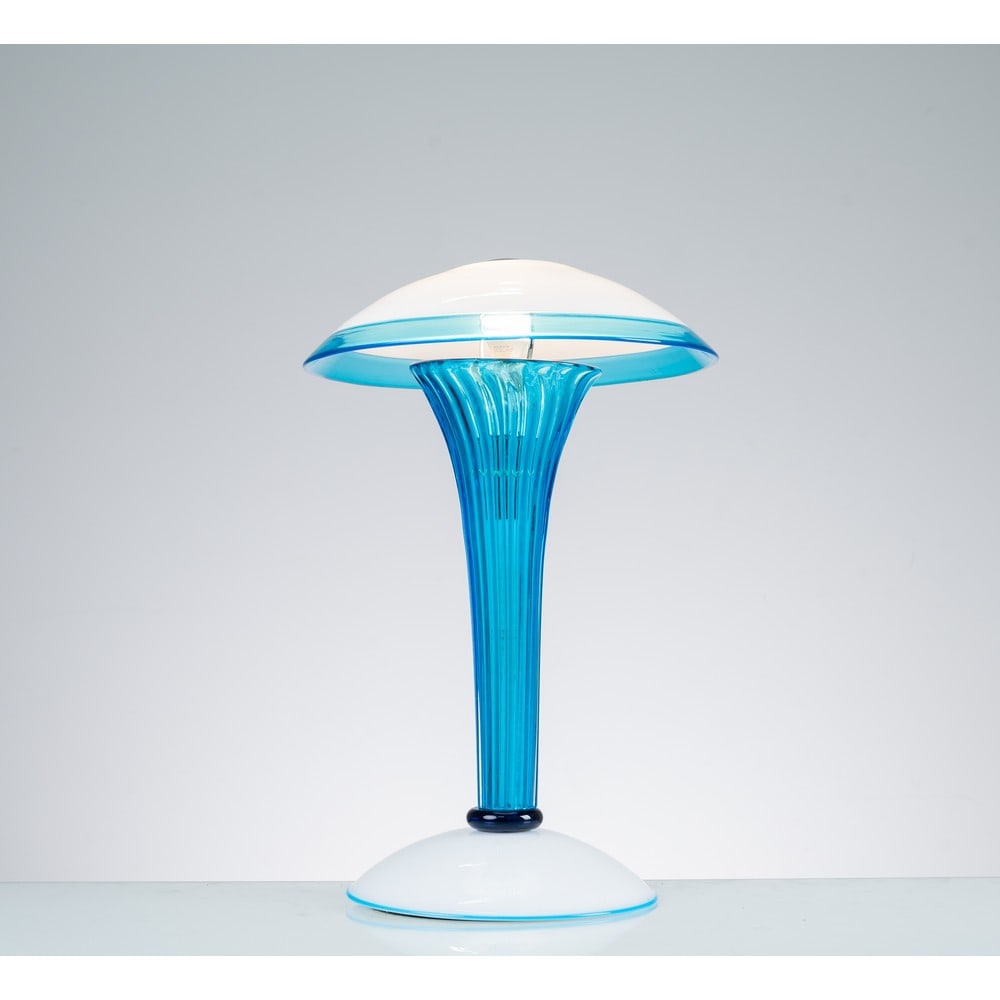 SALVIATI, Lampada da tavolo: SALVIATI Produzione Italia 1980 ca. Lampada da tavolo ad una luce, struttura in vetro con fusto a costolature verticali di colore azzurro, diffusore a fungo in vetro bianco opalino con bordo azzurro, 