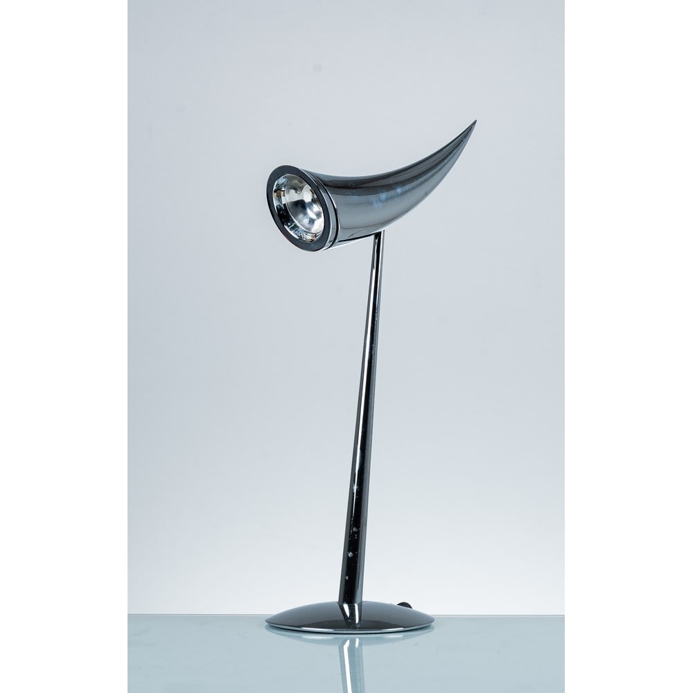 PHILIPPE STARCK, Lampada da tavolo modello “Ara: PHILIPPE STARCK Produzione Flos, Italia 1988 ca. Lampada da tavolo ad una luce modello “Ara”, struttura in metallo cromato con diffusore orientabile conico e curvo. Marchio di produzione. cm h
