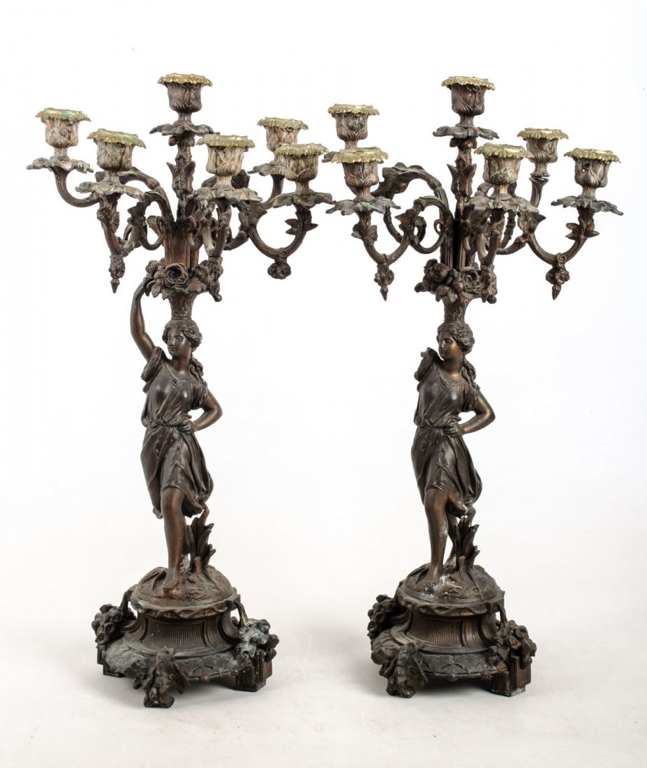 COPPIA CANDELABRI in metallo brunito a sei fiamme: COPPIA CANDELABRI in metallo brunito a sei fiamme sorrette da figure femminili. Italia XIX secolo Misure: h cm 55