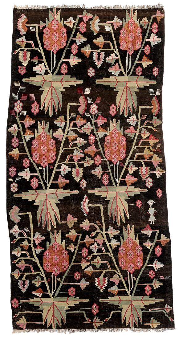 Bessarabian Kilim Carpet: circa 1900, Russia, Ukraine or Moldova, branch, leaf, and humanoid designs on dark chocolate ground, green, red, and burnt sienna highlights, 5 ft. 6 in. x 10 ft. 11 in.. Provenance: Sotheby's London,
