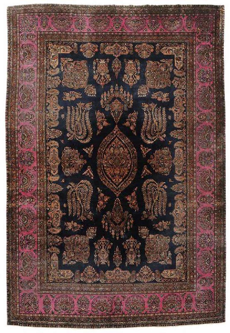 Kerman Carpet: early/mid 20th century, medallion, pendants, and tree of life patterns on cobalt ground, magenta major border 10 ft. 7 in. x 14 ft. 4 in.