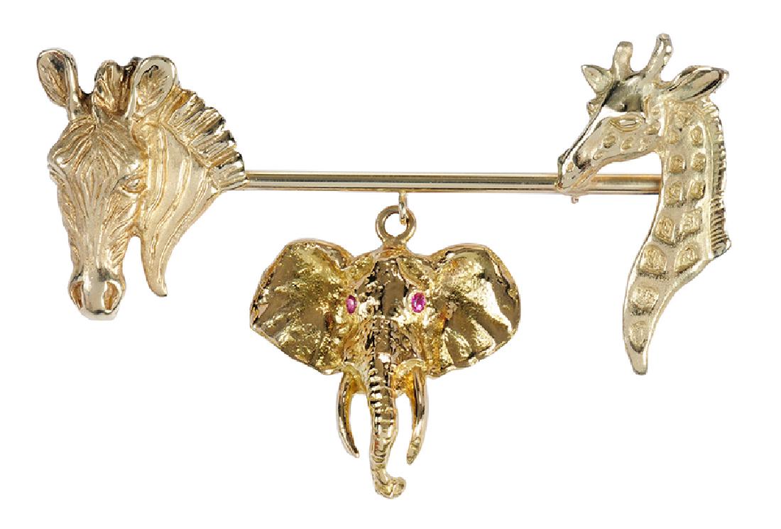 Gold & Ruby Animal Brooch: heads of zebra, giraffe and elephant, elephant with two round faceted rubies approx. 2mm each, zebra hand engraved "Appleby, 1984, 14K", zebra and giraffe tested 14kt., elephant tested 18kt., yellow g