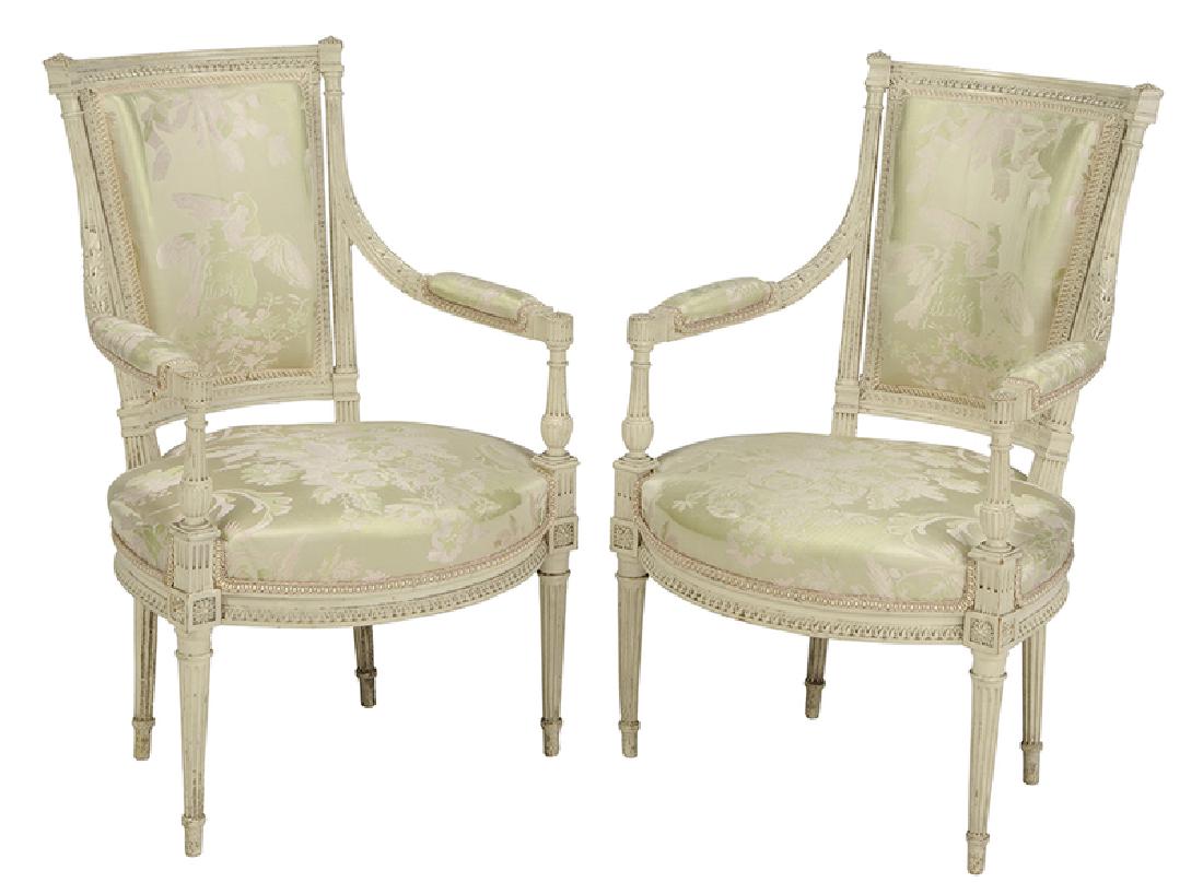 Pair Louis XVI Style Upholstered Arm Chairs: 20th century, each well-carved frame in cream paint, set with fine damask upholstery, 34 in. high