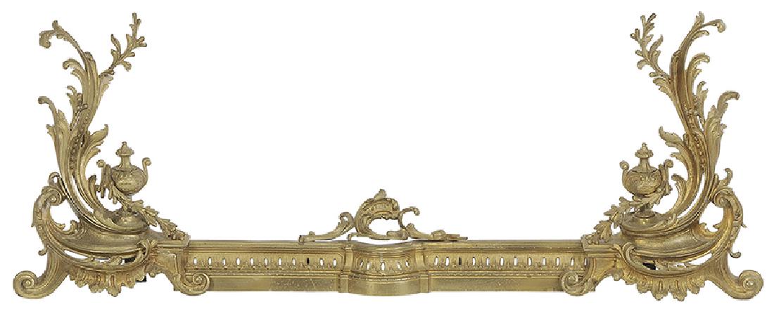 Set of Louis XV Style Gilt Bronze Chenets: French, late 19th/early 20th century, urn and rocaille andirons with associated pierced fender, 19 in.