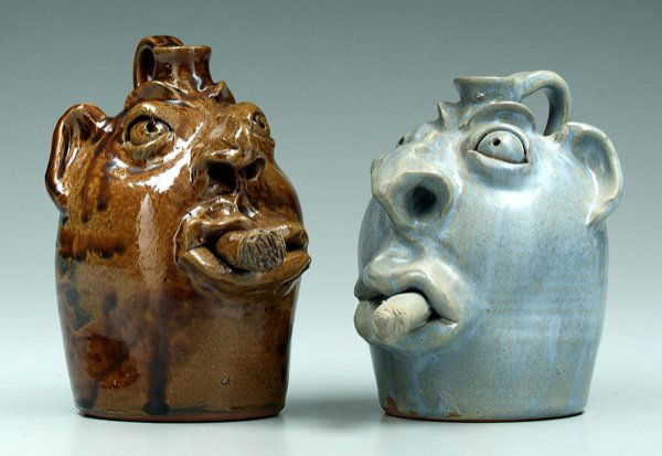 Two Robert Brown face jugs,: with cigars: one brown glaze, base incised "Robert Brown" (Eureka, Montana, born 1953, of Brown's Pottery, Arden, North Carolina), 8 x 5-1/4 x 7 in.; one blue/gray glaze, base incised "Eureka, MT.", 7