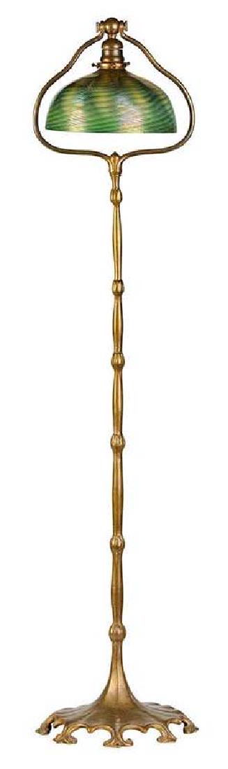 Tiffany Bronze Floor Lamp and Shade: American, early 20th century, cast bronze stand with repeating tulips and scrolled base, stamped on base "Tiffany Studios/New York/425", 55-1/2 in.; green shade with wavy silver iridescent ribs, etche