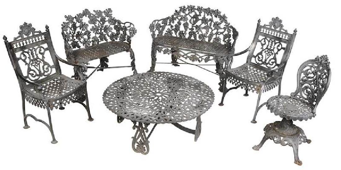 Assembled Suite of Cast Iron Garden Furniture: 20th century, six pieces comprising: two matching grape and vine benches; a pair armchairs marked “Jacobs Mfg. Ala.”; rotating stool; low table, all with black painted surfaces, 33 x