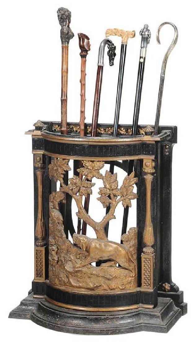 A Sporting Related Iron Umbrella Stand, Six Canes: including British, late 19th century, the gold and black painted stand with hound and pheasant in relief, with a collection of six canes including silver and sporting related, 24-1/2 x 201/2 x 11 in.;