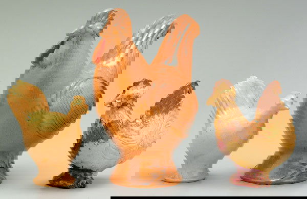 Three earthenware roosters: one with yellow glaze, marks for Jugtown, 1978, 7-1/4"; one with orange glaze, marked "Vernon Owens, Jugtown, 1995", 12-1/4"; one marked "Charles Moore, Jugtown, 1978", 7-3/4", all with firing cracks,