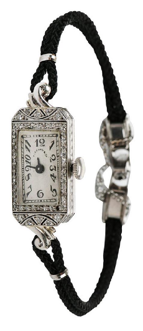 Tiffany & Co., Bulova Platinum Watch: 24 x 13.5mm case, 50 single cut diamonds, dial marked "Tiffany & Co.", inside case stamped "Platinum 30104", movement marked "Bulova, 17 jewels", lugs tested 14kt. white gold, on black cord with stain