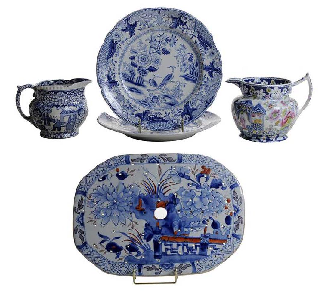 Five Assorted Ironstone Tabletop Objects: British, 19th/20th century, each blue and white decorated, comprising: one clobbered drainer, 13-3/4 in., [spots of discoloration]; two plates with floral and bird decoration, marked "ORIENTAL BI