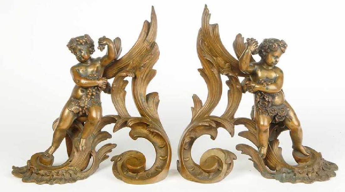 Pair Louis XV Style Gilt Bronze Chenets: French, late 19th century, each rococo form with applied bacchic figural putto mount, 12 x 12 x 5 in. Provenance: Private Collection, Asheboro, North Carolina