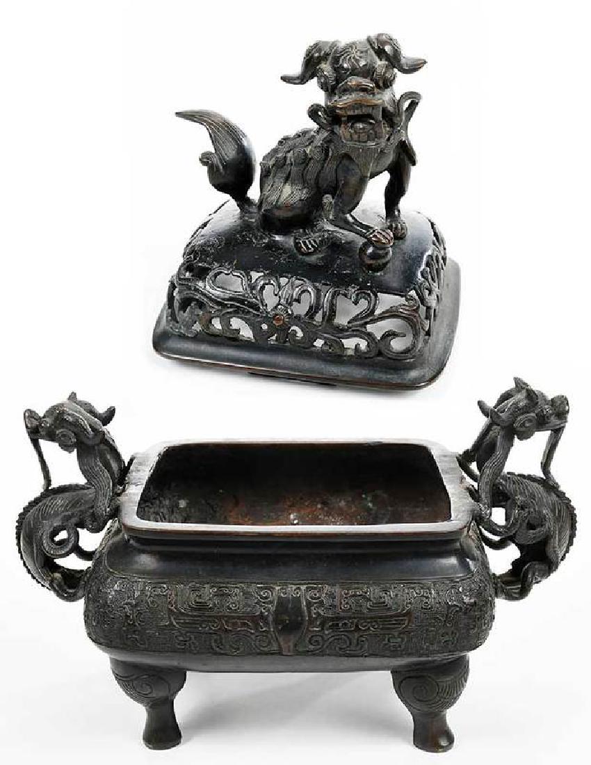 Chinese Patinated Bronze Lidded Censer: impressed seal mark at bottom, body with band of archaic style decoration, pierced lid with foo lion finial, 11-1/2 in. Provenance: Private Collection