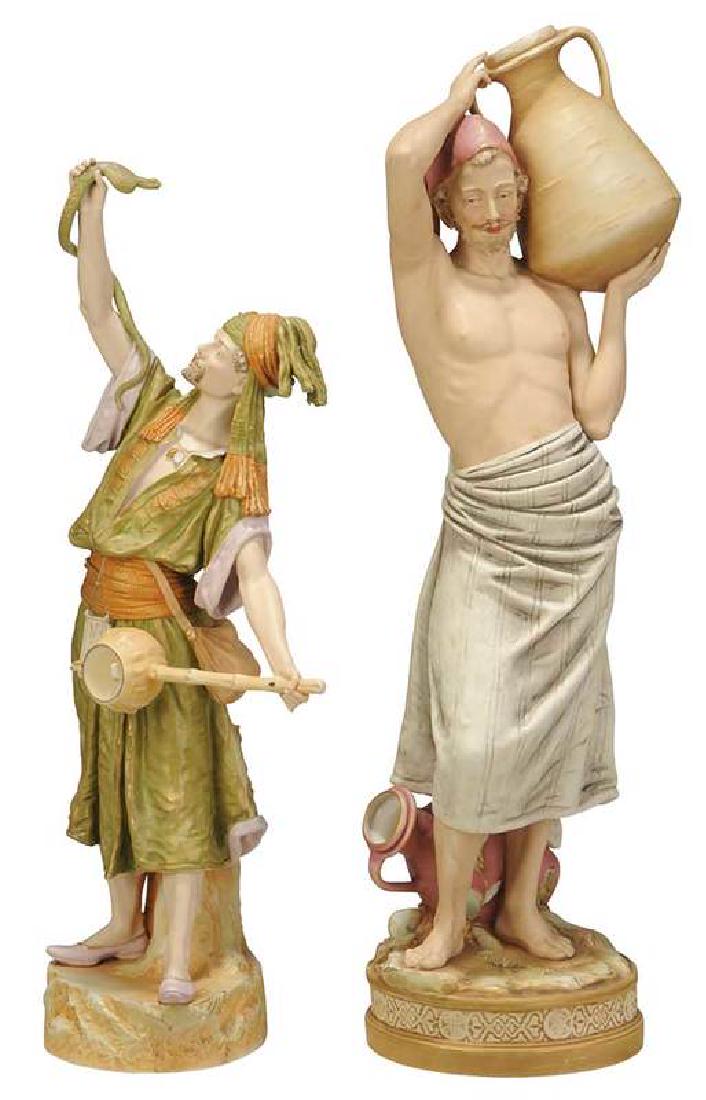 Two Royal Dux Bohemian Porcelain Figures: early 20th century, two Middle Eastern men, one holding a snake, impressed "888" on bottom, 27 in.; bare chested man with water jug, impressed "1433", 31-1/2 in., both with applied triangular Royal Du