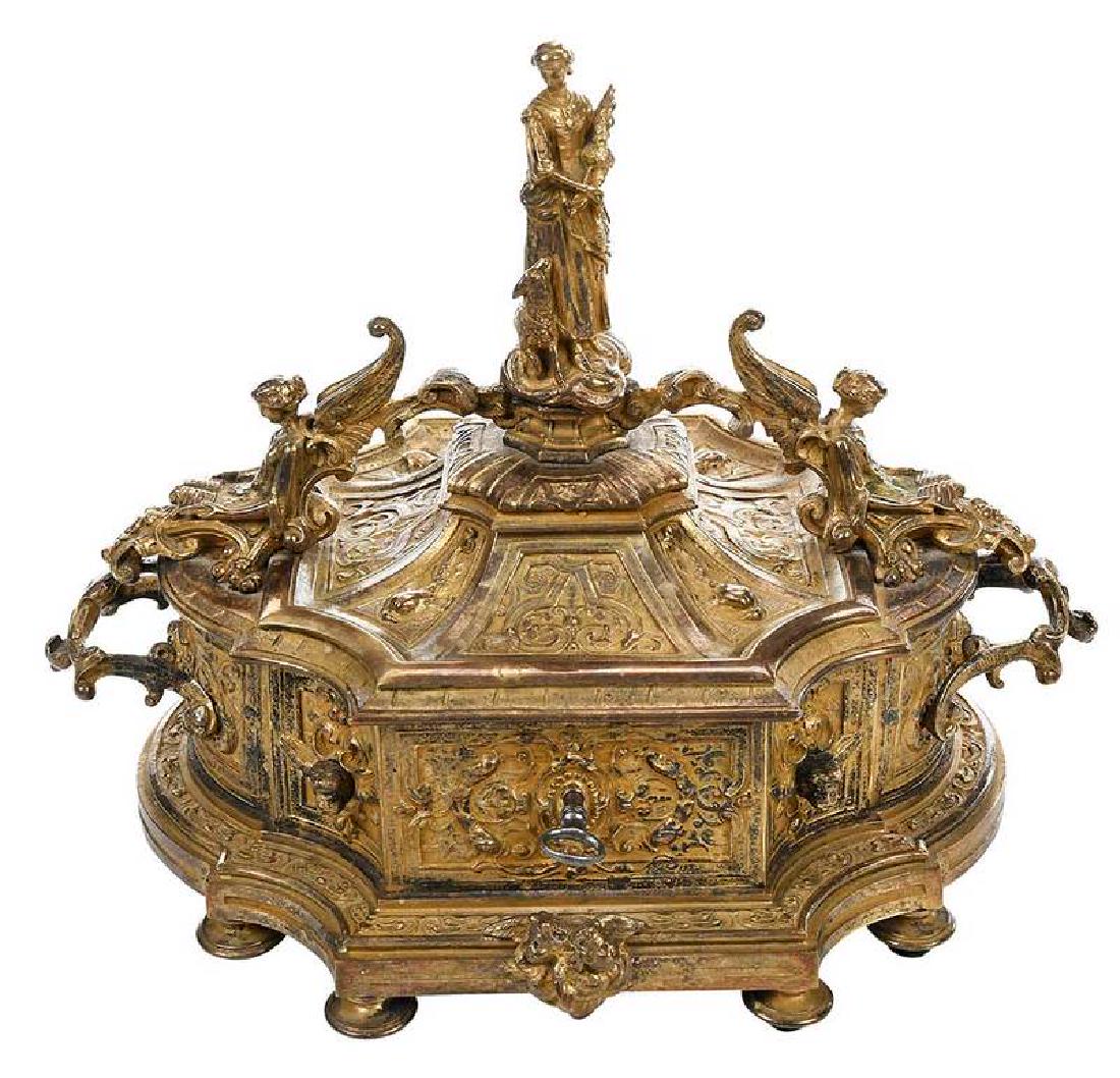 Louis XV Style Gilt Bronze Jewelry Casket: probably French, 19th century, cartouche shaped casket, hinged lid with classical figures and finial, overall relief decoration of cherubs and other classical motifs, opens to burgundy velvet interior