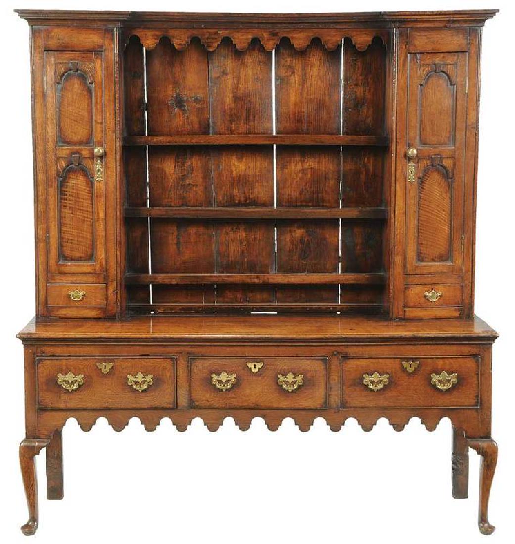 Good Welsh Oak Cupboard and Rack: British, 18th century, a rich dark color, the rack is flanked by double-panel doors over single drawers, the three-drawer dresser with pierced brass pulls and a scalloped skirt, 75 x 67-1/4 x 19-1/2 i