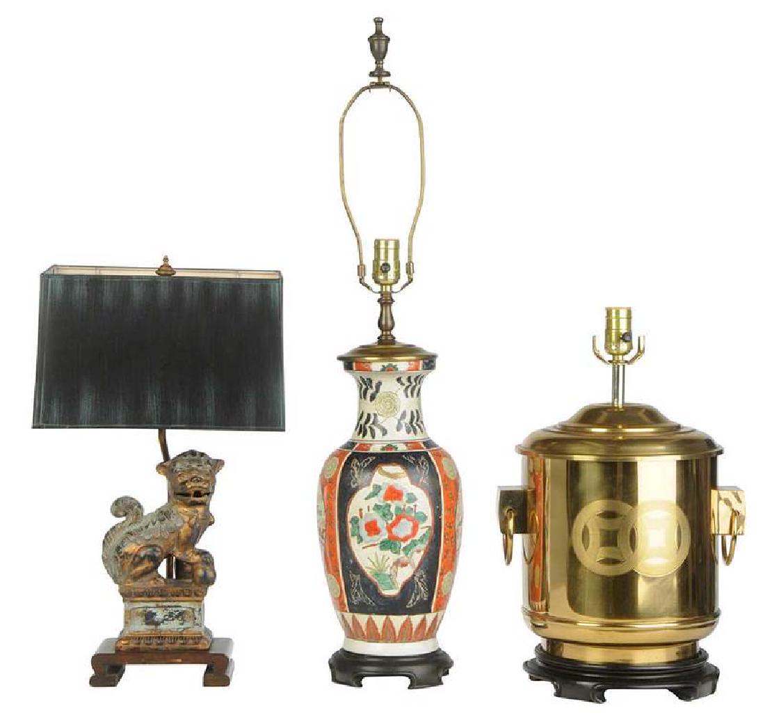 Three Asian Style Table Lamps: 20th century, comprising: label for Frederick Cooper, bronze foo dog mounted on wooden base, to socket 14-3/4 in.; together with painted paper shade, 20 in.; brass handled vessel, lacquered wooden bas