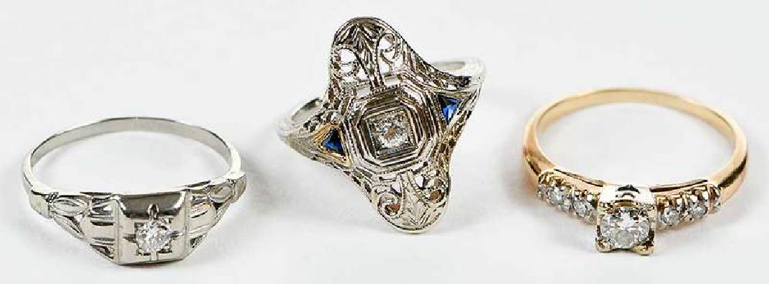 Three Gold & Diamond Rings: filigree ring, one round brilliant diamond, two blue stones, stamped "S18K", white gold, size 4-1/2, 2.8 grams [yellow gold repairs around trillion blue stones, wear and scratches]; retro ring, one ol