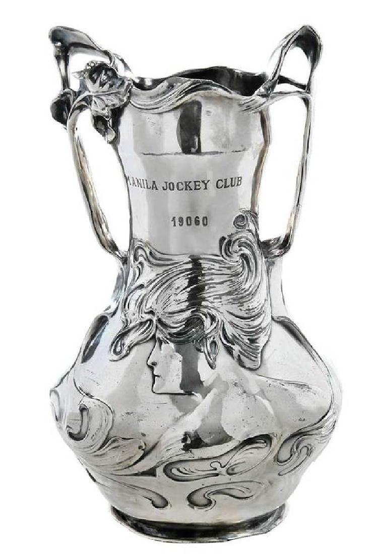 Art Nouveau Manila Jockey Club Horse Trophy: German, circa 1900, silver plate cast pewter, relief figural woman head and iris motif, iris motif double handles, designed by J.R. Hannig (signed to right hip of design), made by F.X. Dautzenberg (se