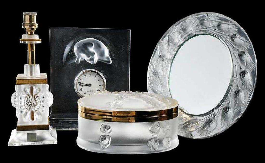 Four Lalique Glass Dresser Items: dresser or desk clock with molded cat decoration, 7-3/4 x 7-1/4 in.; small lamp, 8-3/4 in. to socket; oval dresser box with hinged lid, 3 x 6-1/2 in.; oval thistle mirror with easel back, 9-1/2 x 8 in