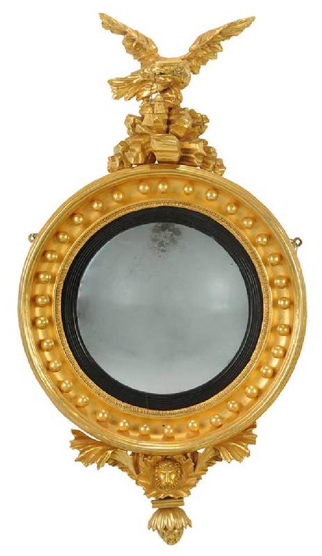 Regency Carved Gilt Wood Eagle Convex Mirror: American or British, circa 1925, eagle perched on rocky plinth, lion head and foliate pendant, 34-1/2 x 18-1/2 in. , Provenance: Property from an Important South Carolina Estate