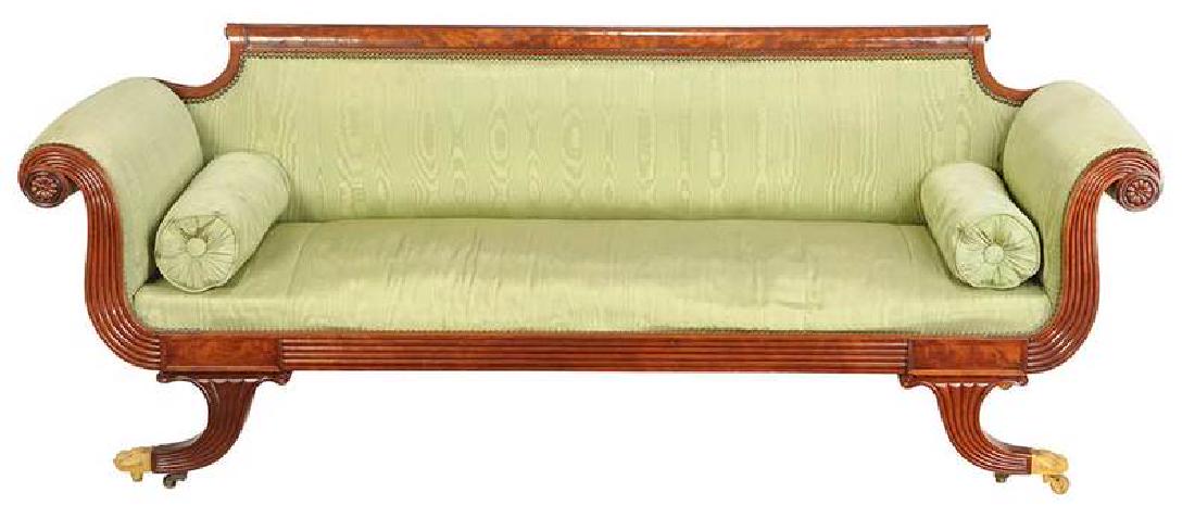 American Classical Figured Mahogany Sofa: New York, circa 1830, in the manner of Duncan Phyfe, carved frame with scrolled arms set with rosettes, gilt brass paw casters, green silk upholstery with brass tacking, 32 x 83 x 24 in. , Provenance: