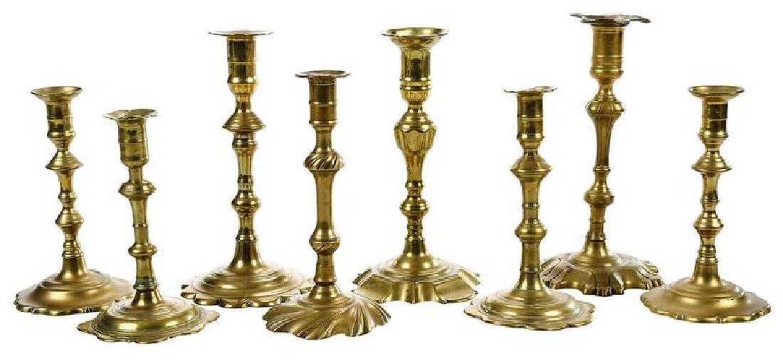 Eight Georgian Brass Candlesticks: British, 18th century, various scalloped petal, swirl and scalloped bases, 7-1/4 in. to 9-1/2 in. , Provenance: Mark and Marjorie Allen Antiques, New Hampshire; Northeast Auctions, (attached labe