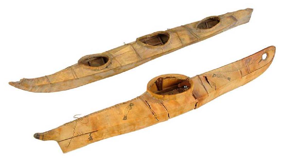 Two Inuit Kayak Models: early 20th century, painted hide model with images of fish and birds, wood frame with woven fiber interior, 36 in.; model with three openings, probably seal hide/skin over wood frame, 42 in. , Pr