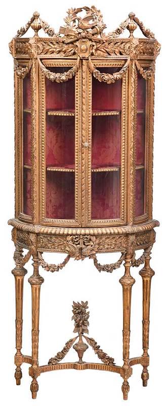 Louis XVI Style Carved and Gilt Vitrine: French, late 19th/early 20th century, two glazed doors and fabric lined interior, elaborate garland and leaf carving, trophy crest, on conforming stand with stretchers, 69 x 25-1/2 x 12 in.; Provenanc