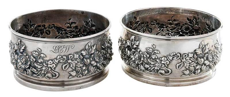Pair of Sterling Reposse Wine Coasters: American, early 20th century, round with band of floral repousse decoration, wooden bases, marks forÿMauser Manufacturing Co. (Mt. Vernon, New York, working 1892-1913),ÿ2-3/4 x 5 in.; Provenance: Pr
