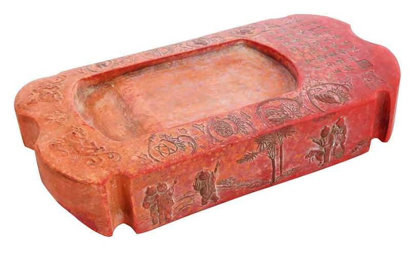 Chinese Armrest Inkstone: 19th/20th century, rectangular red clay body with canted corners, recessed interior, raised border design with?people flying kites,?characters, and seal, curved underside with floral and landscape mot