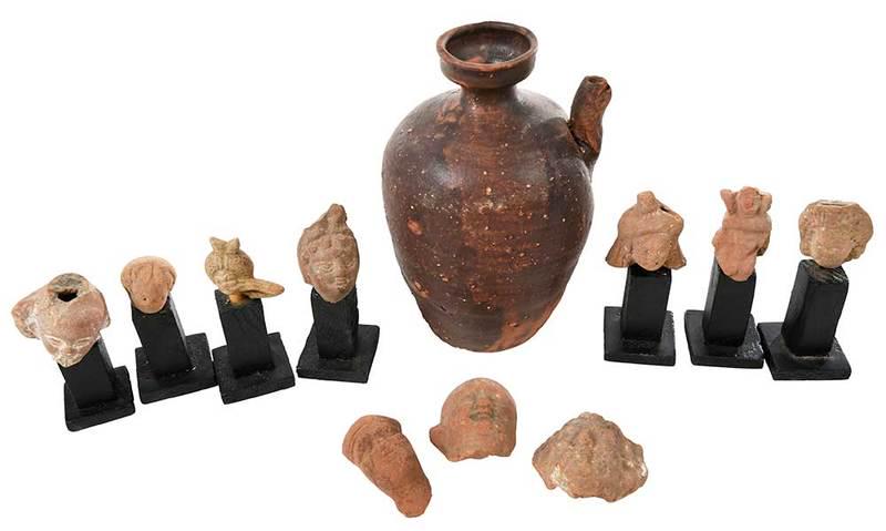 Ten Greek or Roman Terracotta Head Fragments: possibly ancient, five probably of women, some with detailed hair and headdresses; five probably of men; some with wood stands, largest approximately 2-1/2 in.; together with a small earthenware jug w