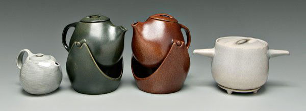 Four pieces Raymor pottery: two teapots on stands, one brown glaze, one olive glaze, marked "Raymor" and "Roseville", each 12-1/4 in., [olive teapot with rim chip, repair to sleeve on lid; brown teapot with repaired lid, interio