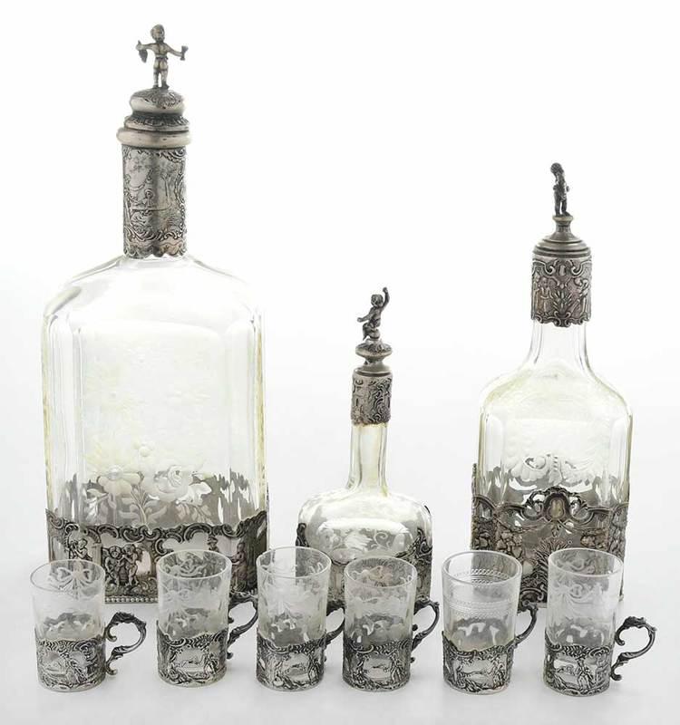 Silver and Glass Cordial Set, Nine Pieces: ˜possibly German, 20th century, intaglio cut glass, silver with courting scenes, including three decanters and six cups, 2-1/4 in. to 11 in.Provenance: Private Collection, Pinehurst, North Carolina