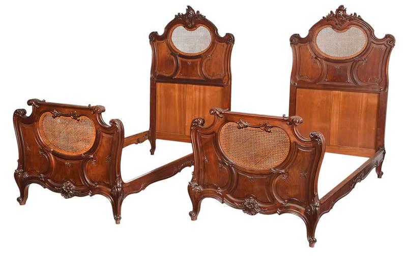 Fine Pair Provincial Louis XV Style Walnut Beds: French, 20th century, finely carved frames set with double caned panels, leaf and scroll decoration, paneled backs, 67 x 41 x 84 in.ÿ