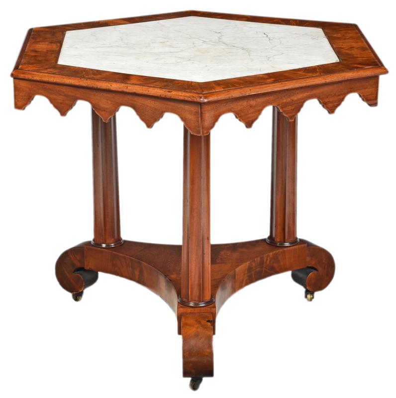 American Gothic Revival Marble Top Center Table: probably New York, mid 19th century, highly figured mahogany, hexagonal top with white marble inset, scalloped skirt in the Gothic taste, on fluted supports and scrolled feet, 28-1/2 x 38 x 38 in.; ac