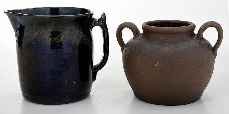 Two Pieces of Bachelder Pottery: (Oscar Louis Bachelder, b. 1852 Menasha, Wisconsin, d. 1935 Luther, North Carolina) large black glazed pitcher, flared rim, unusual applied handle, 7-1/2 in.; matte brown glazed bean pot, two applied 
