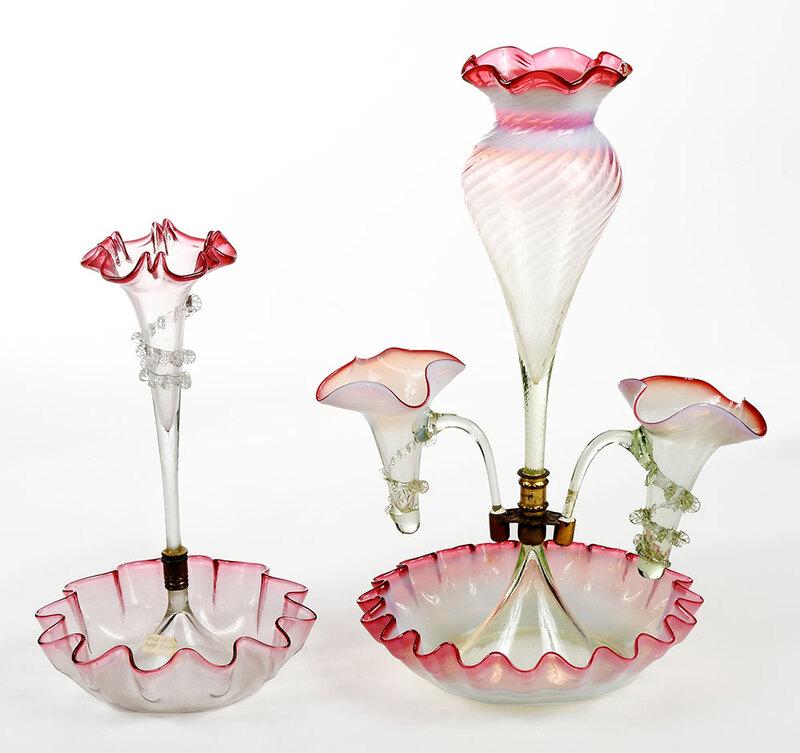 Two Victorian Pink Glass Epergnes: late 19th century, central trumpet and two smaller trumpets with spiraling rigaree decoration, on a round base with ruffled rim, 16-1/2 x 9 in.; epergne with single trumpet with spiraling rigaree deco