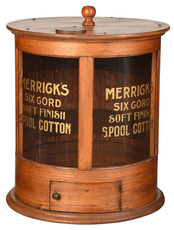 American "Merrick's" Oak Country Spool Cabinet: with metal patent label for July 20, 1897, round table top spool cabinet with two curved glass panels with store advertisement for "Merrick's Six Cord Soft Finish Spool Cotton" painted in gold, small
