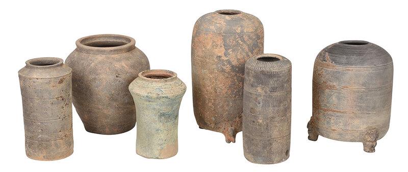 Six Early Chinese Earthenware Storage Jars: possibly Han or Tang dynasty, two granaries, both with three animal form feet and incised concentric bands, tallest 13 in.; three cylindrical jars with incised decoration, 9-1/2 in.; bulbous jar, 9 in