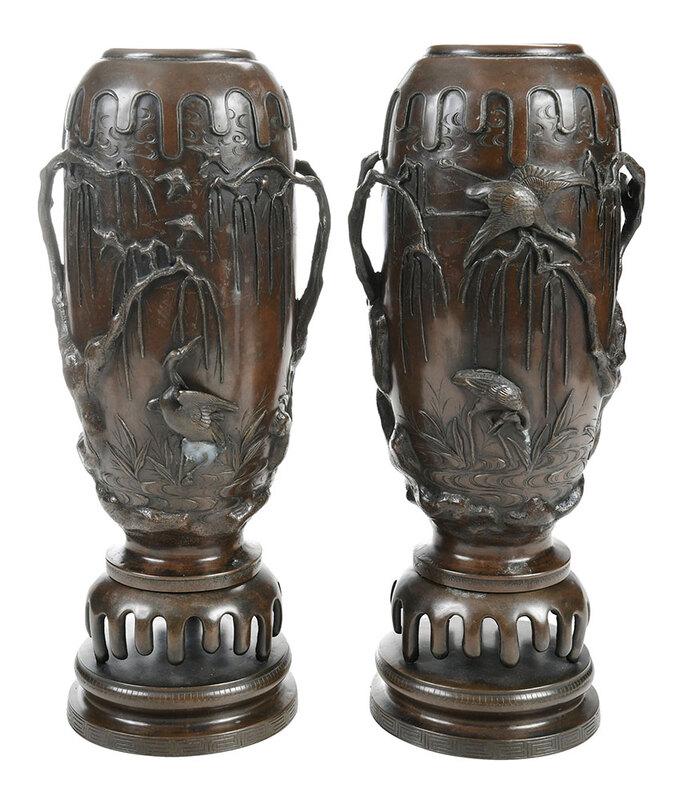 Pair Japanese Patinated Bronze Vases on Stands: Meiji period, cylindrical form with high relief decoration of cranes wading in the water, trees and birds overhead, applied "drip" decoration that corresponds to the decoration on the bronze bases, bo