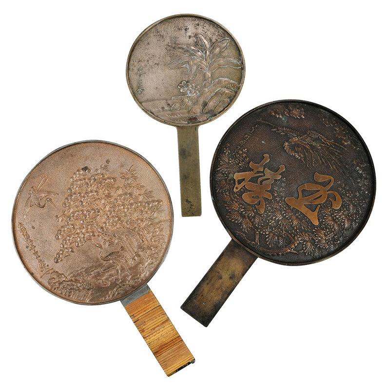 Three Japanese Bronze Hand Mirrors: 19th century, of varying sizes, with crane, floral, and foliage decoration, one with fitted wood case, largest 11 x 7-1/4 in. - Provenance: