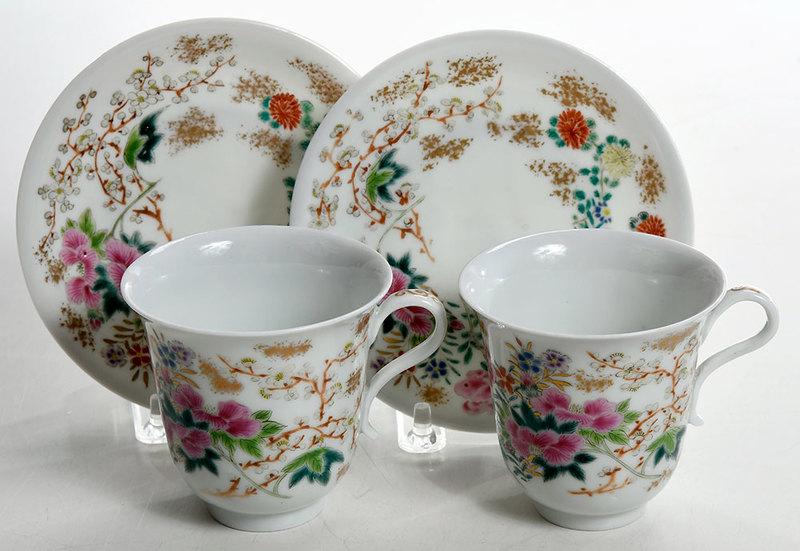 Pair Japanese Export Enameled Cups and Saucers: probably late Edo period, brightly enamel decorated with blossoms, gilt accents, six character iron red mark to bases,ÿhandled cups, 3 in.; saucers, 5-1/8 in.Note: Objects from this personal coll