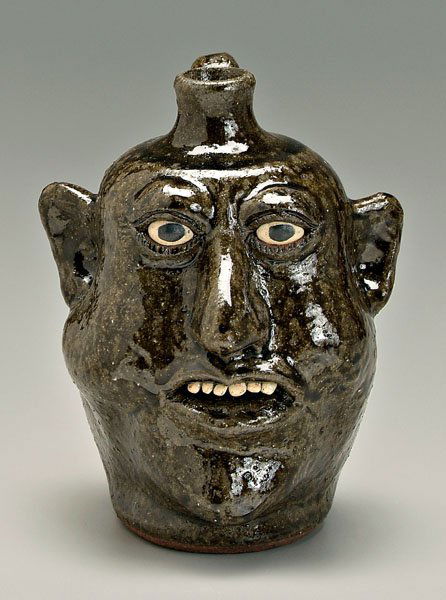 Lanier Meaders face jug,: runny medium alkaline glaze stoneware, ceramic teeth, painted eyes, signed on base "Lanier Meaders" (White County, Georgia, 1917-1998), 8-3/4 in. Excellent condition. Provenance: The Collection of Sam