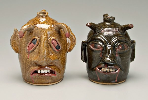 Two Reggie Meaders devil jugs: (White County, Georgia, born 1916), one with runny honey-colored alkaline glaze, horns, applied ceramic eyes and teeth, blood on horns, eyes and mouth, marked on back "Reggie Meaders 1/1/2001", 9 in.;