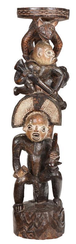 Cameroon Carved and Polychromed Figural Stand: African, circa 1900, with circular top over a jaguar or leopard figure standing over a figure holding a gun, over a seated Chief wearing a crescent shaped hat and holding a drinking horn, on a snake a