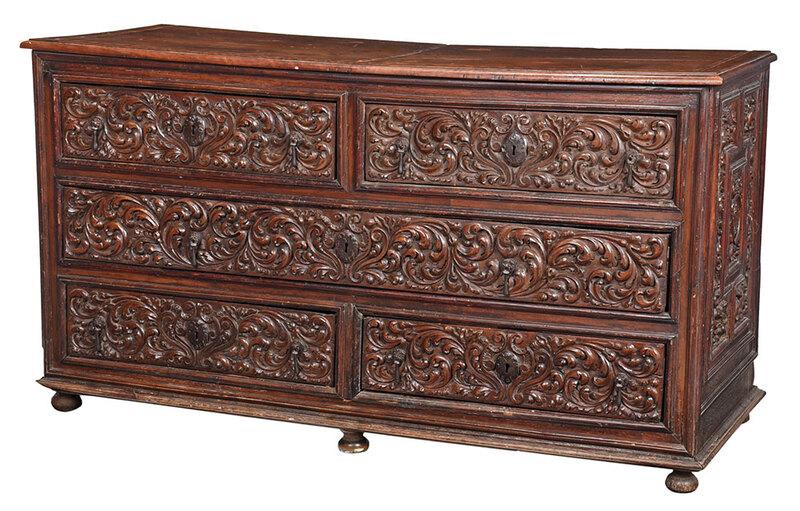 Baroque Highly Carved Walnut Grand Commode: probably Italian, 17th century, figured walnut top with barber pole inlaid banding, over five elaborately carved drawers set with original iron locks, escutcheons, and teardrop drawer pulls, carved an