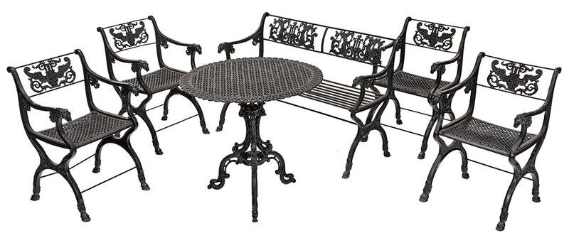 Vintage Six Piece New Orleans Style Garden Suite: in the style of Karl Friedrich Schinkel, comprising four cast iron armchairs and bench, each with putti and lyre figural backs and goat's head hand grips,ÿbench 31 x 28 x 20 in., chairs 31 x 21-1/2 x