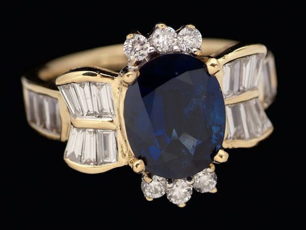 Sapphire, diamond ring,: central oval sapphire, estimated weight 2.30 cts., surrounded by six round brilliant-cut diamonds and 18 baguette diamonds, total estimated weight .65 cts., 18 kt. yellow gold mount, size 6; insurance